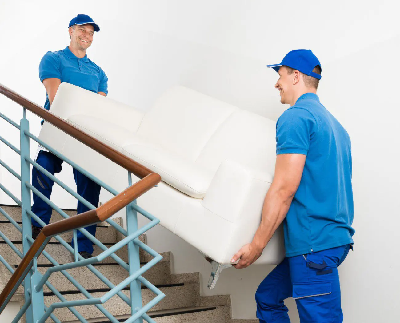 Movers carrying a sofa up stairs.