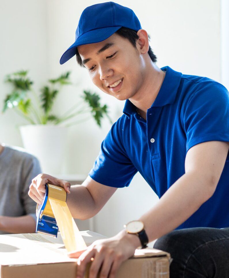 Person sealing a cardboard box with tape.